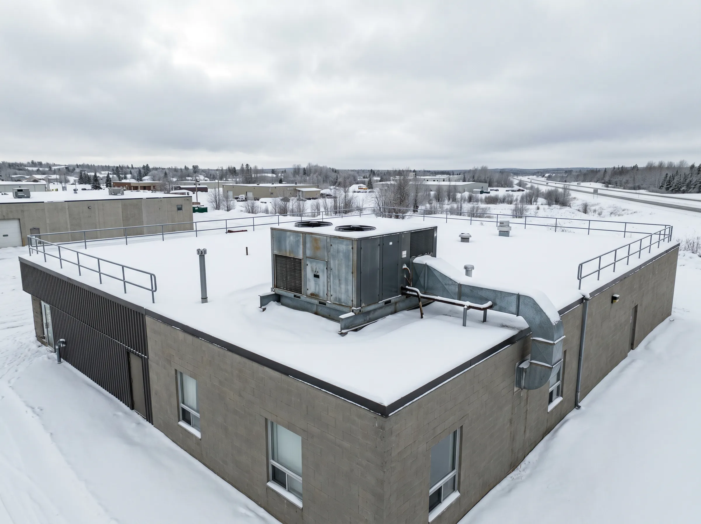 Commercial rooftop HVAC unit on a flat-roof building in Timmins in winter