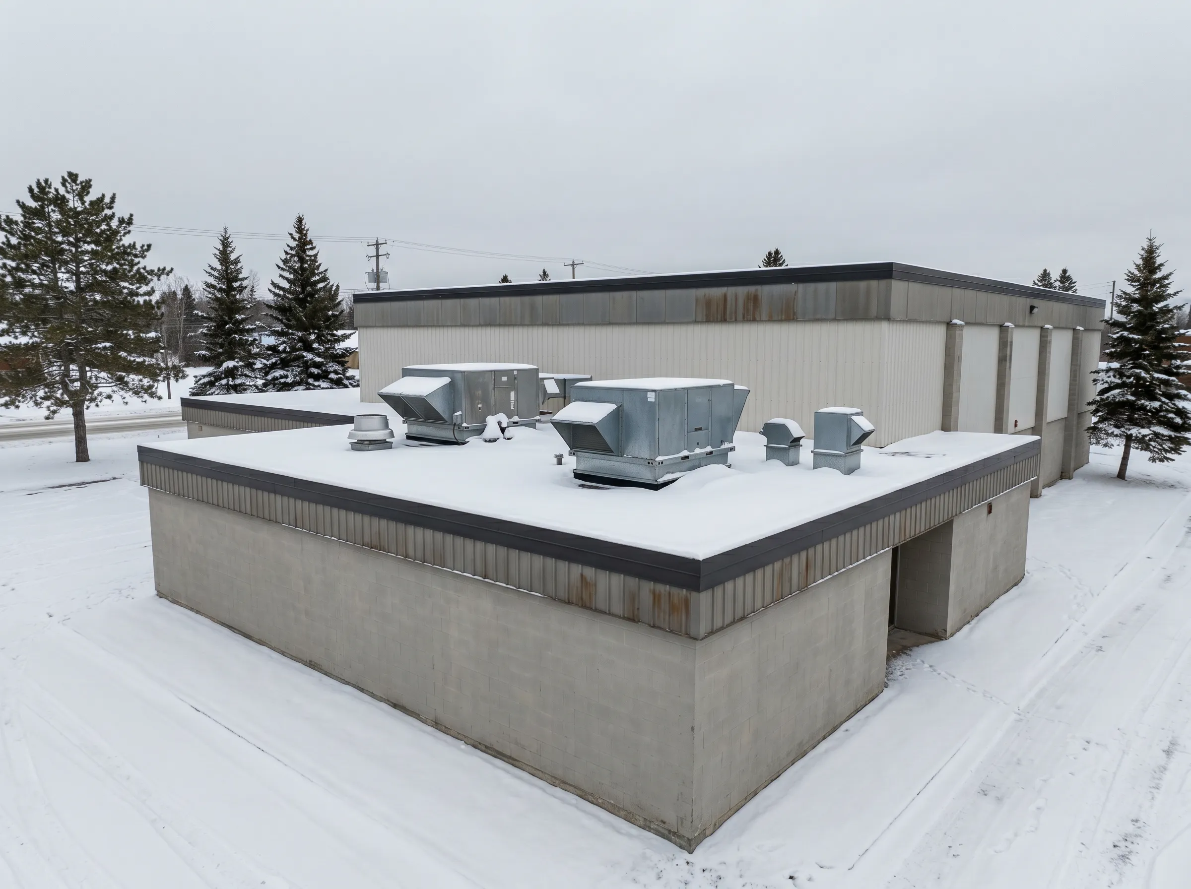 Commercial building in Timmins with rooftop HVAC units in winter snow
