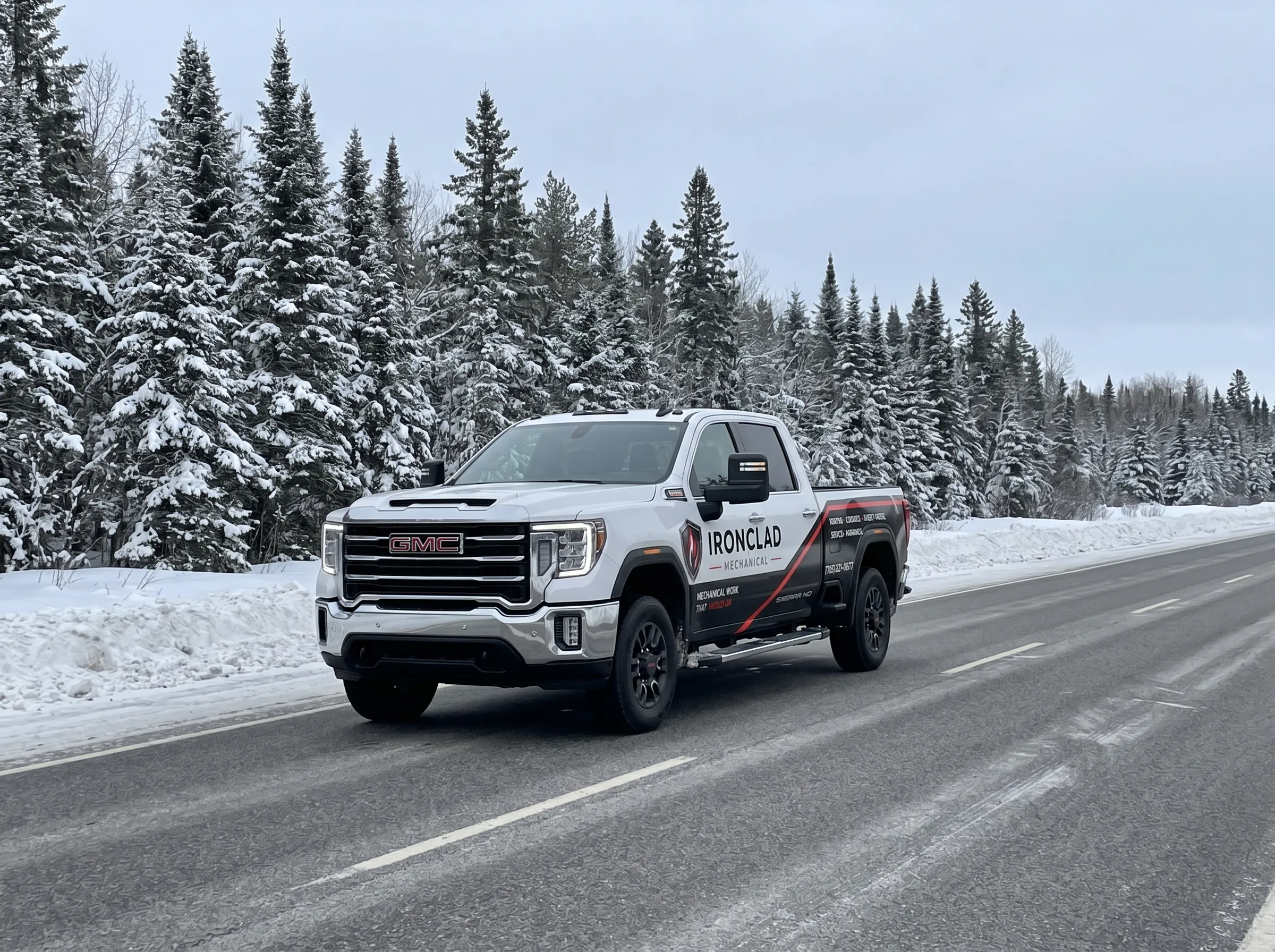 Ironclad Mechanical GMC service truck on a snow-lined Northern Ontario highway in winter